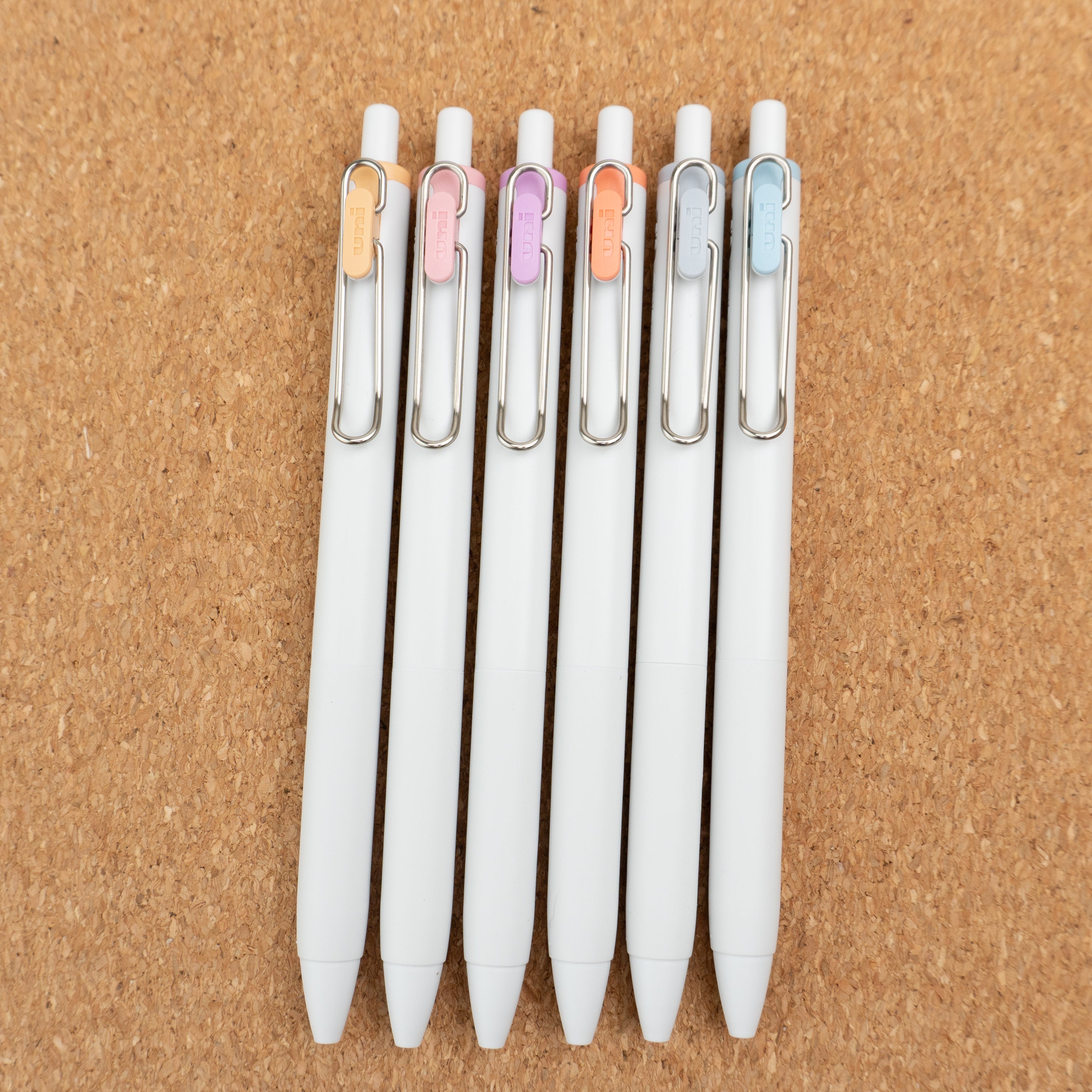 Uniball One 2024 Summer Yuru Matope Limited Edition Gel Pens Angled On Cork Background